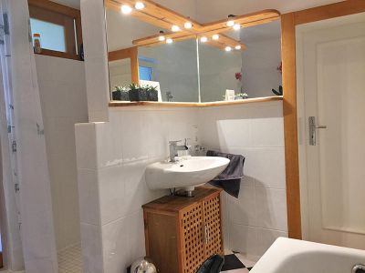 Badezimmer mit Dusche, Badewanne, Waschmaschine und Föhn